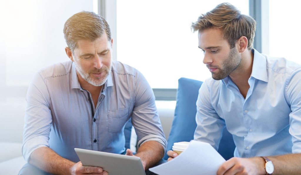 2 sales men review numbers in the office